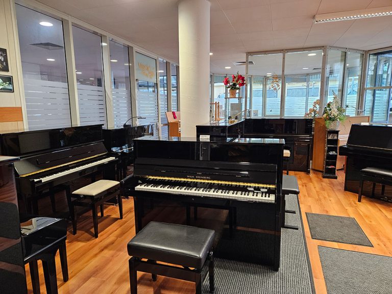 Klaviere mit offener und geschlossener Tastatur, die zum Verkauf stehen.